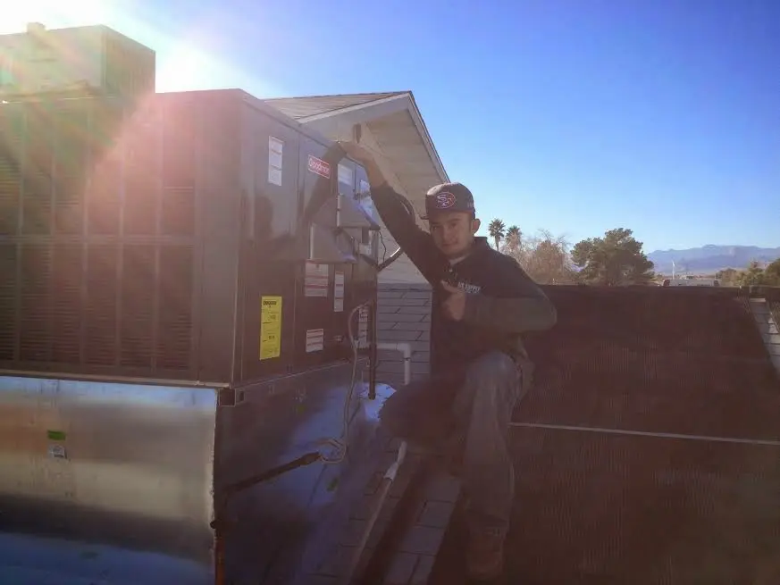 HVAC technician performing Heat Pump Repair on a rooftop unit in Albany